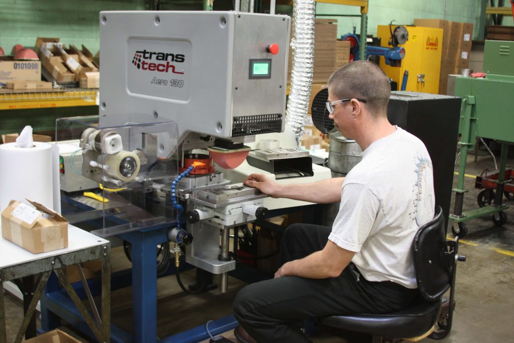 A photo of Ramcel engineers working with custom stamping machinery